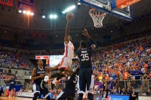 Florida Gators forward Dorian Finney-Smith posterizes UCONN Huskies guard Terrence Samuel during the second half.  Florida Gators vs UCONN Huskies.  January 3rd, 2015. Gator Country photo by David Bowie.