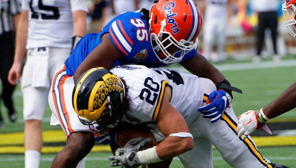 Florida Gators defensive lineman Keivonnis Davis tackles Michigan running back Drake Johnson during the 2016 Buffalo Wild Wings Citrus Bowl- Florida Gators football- 1280x855