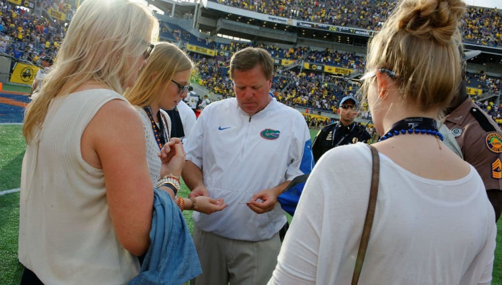Florida Gators head coach Jim McElwain gives out gum to his daughters, a post game ritual for the family, after losing to the University of Michigan Wolverines - Florida Gators football- 1280x852