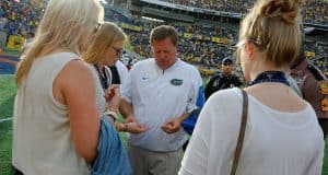 Florida Gators head coach Jim McElwain gives out gum to his daughters, a post game ritual for the family, after losing to the University of Michigan Wolverines - Florida Gators football- 1280x852