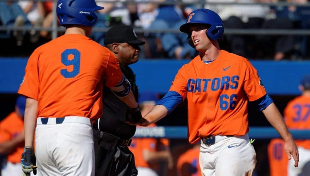 University of Florida senior Ryan Larson celebrates with Christian Hicks after scoring to give UF a 5-2 lead over Miami- Florida Gators baseball- 1280x852