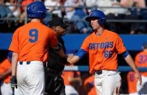 University of Florida outfielder Ryan Larson celebrates with Christian Hicks after scoring a run against Miami- Florida Gators baseball- 1280x852