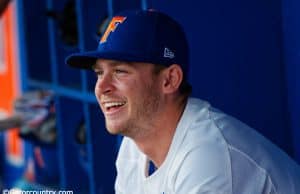 University of Florida infielder Deacon Liput sits in the dugout as the Florida Gators warm up before their season opener against Siena- Florida Gators baseball- 1280x853