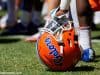 A player rests on his helmet while Dan Mullen addresses the Florida Gators football team after a spring practice- Florida Gators football- 1280x853