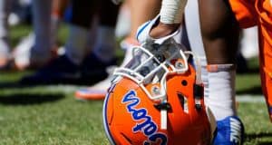 A player rests on his helmet while Dan Mullen addresses the Florida Gators football team after a spring practice- Florida Gators football- 1280x853