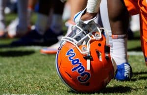 A player rests on his helmet while Dan Mullen addresses the Florida Gators football team after a spring practice- Florida Gators football- 1280x853