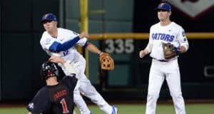Jun 17, 2018; Omaha, NE, USA; Texas Tech Red Raiders center fielder Cody Farhat (1) slides into second base as Florida Gators second baseman Blake Reese (12) completes a double play with shortstop Deacon Liput (8) watching in the third inning during the College World Series at TD Ameritrade Park. Mandatory Credit: Steven Branscombe-USA TODAY Sports