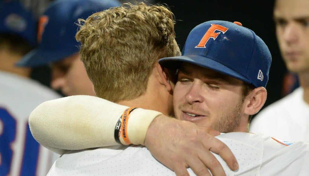 Jun 22, 2018; Omaha, NE, USA; Florida Gators second baseman Blake Reese (12) and shortstop Deacon Liput (8) hug after the loss against the Arkansas Razorbacks in the College World Series at TD Ameritrade Park. Mandatory Credit: Steven Branscombe-USA TODAY Sports