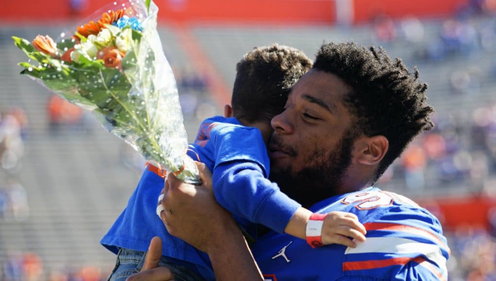 Florida Gators defensive lineman Cece Jefferson holds his son during senior day- 1280x1024