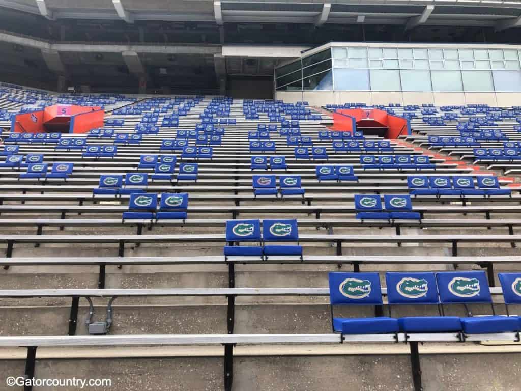 Padded chair back seating has been placed over bleachers to create six feet of distance between people at football games in 2020- Florida Gators football- 1280x960